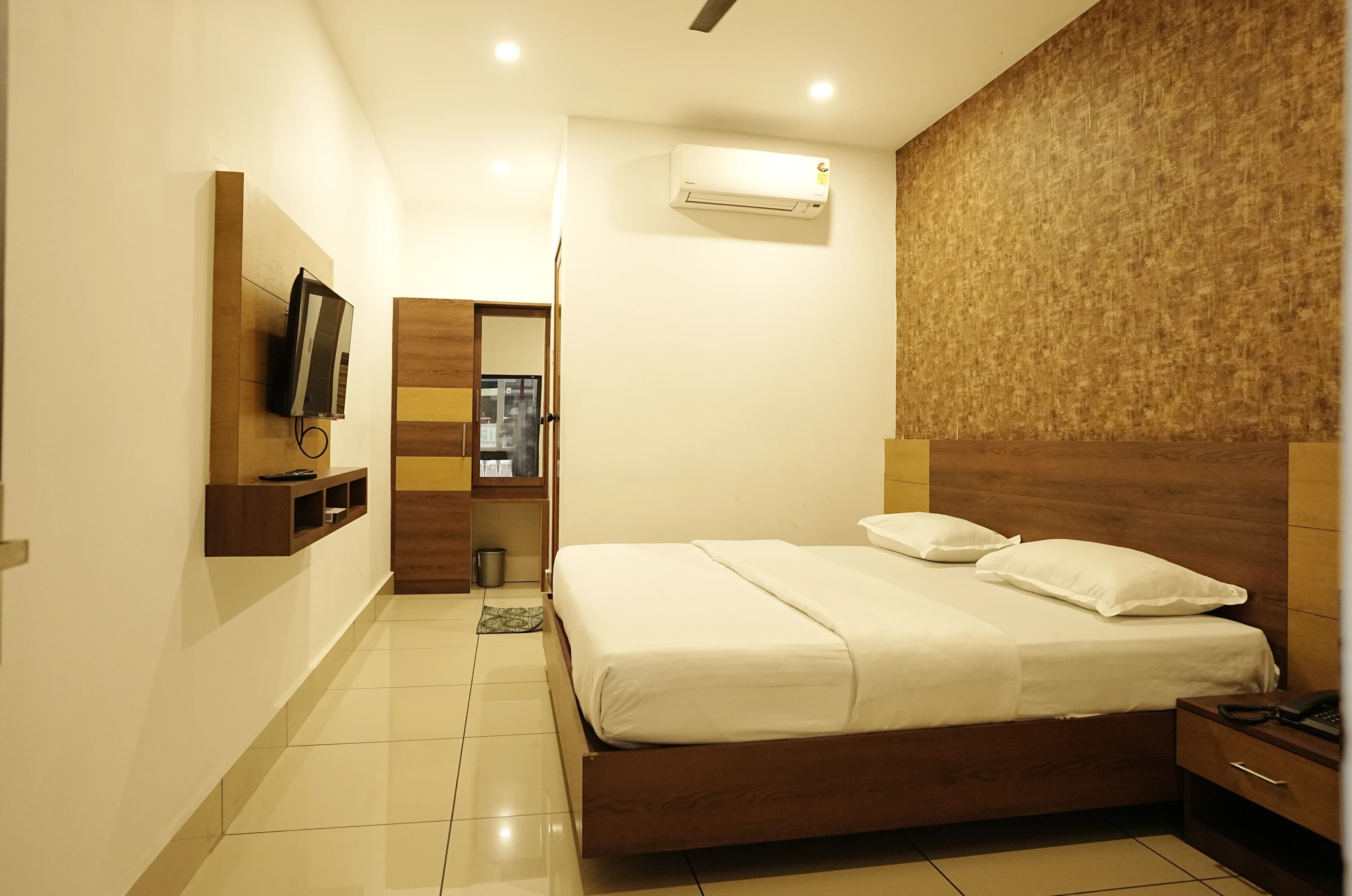 Neatly made bed with fresh linen at Affas Udupi Hotel Kalpetta